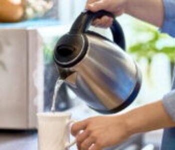 Female,Hands,Pouring,Boiling,Water,From,A,Modern,Metal,Stainless